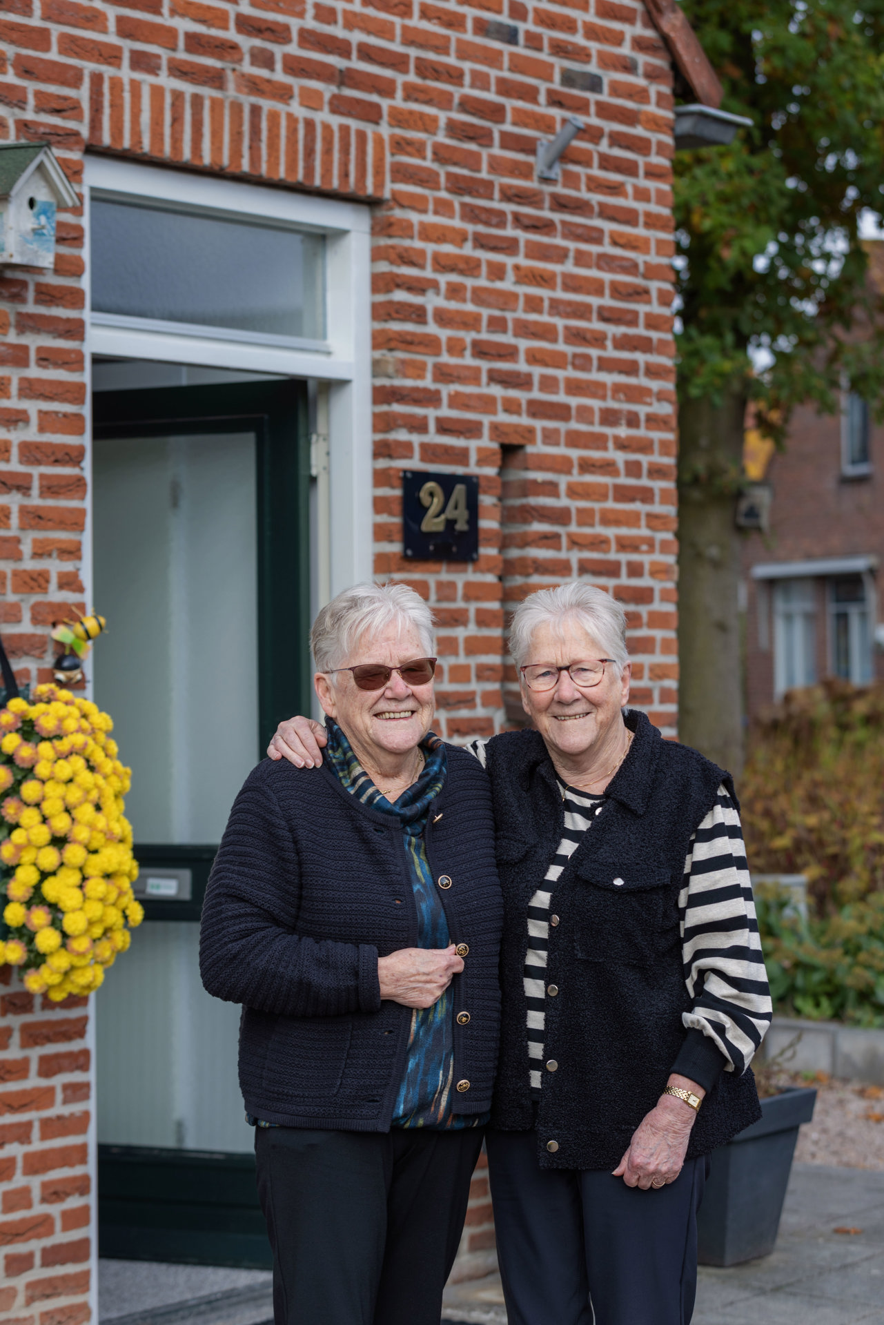 Zussen voor hun woningen als buren